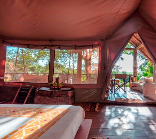 塔勒克马赛马拉营地酒店的帐篷配有一张床和一张桌子及椅子
