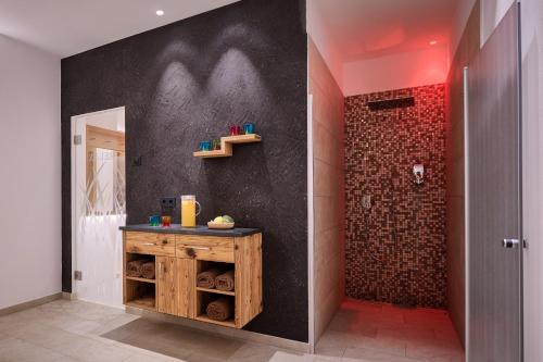 卡斯特尔罗托加尼萨沃伊酒店的配有带木制梳妆台和墙壁的淋浴的浴室