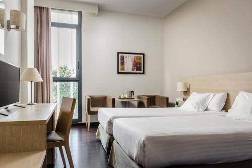 圣胡安德斯皮巴塞罗那盖特埃克酒店的酒店客房设有一张大床和一张书桌。