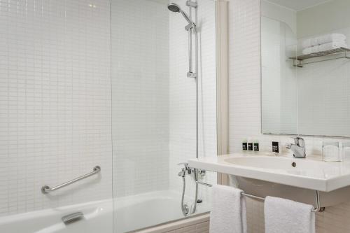 圣胡安德斯皮巴塞罗那盖特埃克酒店的白色的浴室设有水槽和淋浴。