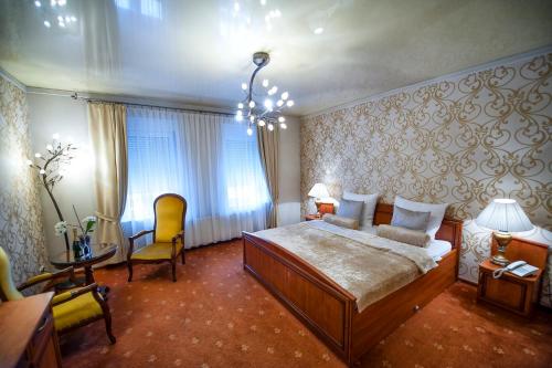 希隆斯克地区佩卡雷帝权酒店的一间卧室配有一张大床和一张桌子及椅子