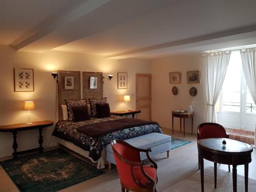 Neuvy-au-Houlme瑞巴洞庄园旅馆的卧室配有一张床和一张桌子及椅子