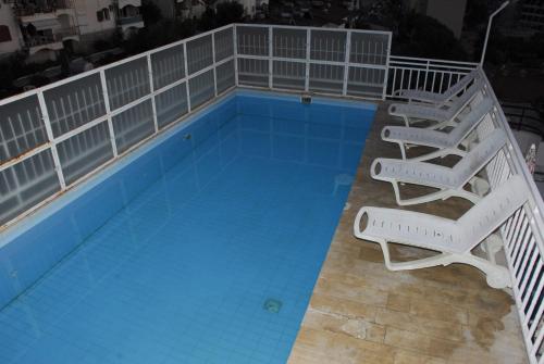 库萨达斯奥兹根公寓式酒店的一个带2把躺椅的游泳池和一个游泳池