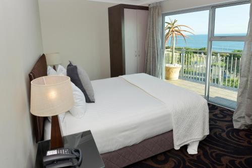 新普利茅斯新普利茅斯海滨千禧酒店的酒店客房设有一张床和一个阳台。