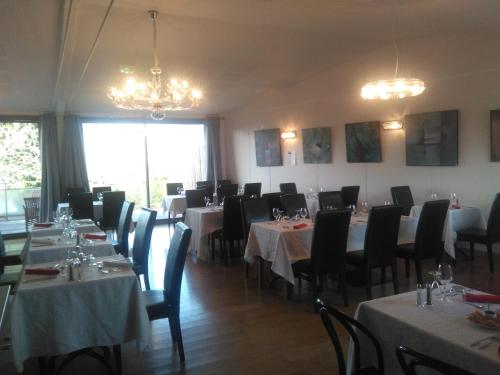 Teissières-lès-BoulièsL'Auberge de Teissières的用餐室配有桌椅和吊灯。