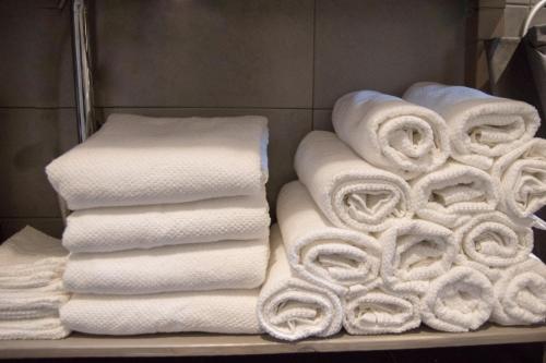 LauwerzijlBed en breakfast Uitrust的浴室架子上的一大堆毛巾