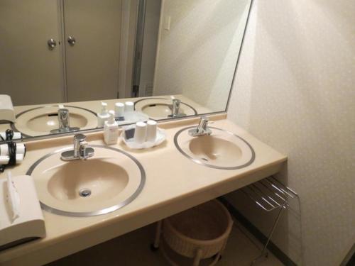 安昙野市安昙野市穗高景酒店的一间带三个水槽和大镜子的浴室