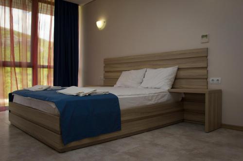 StambolovoComplex Perpera的一间卧室配有一张带木制床头板的床