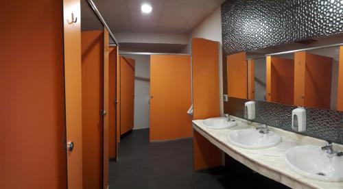 阿尔苏阿Cruce De Caminos Arzua的一间带三个水槽和橙色墙壁的浴室