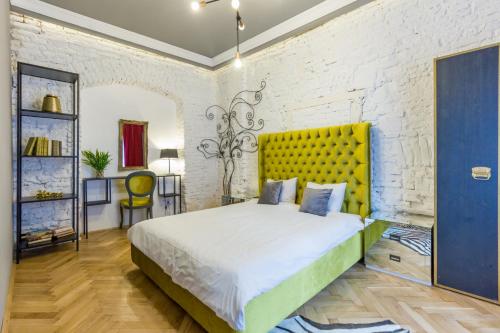 克卢日-纳波卡Köte Haus的一间卧室配有一张带黄色床头板的大床