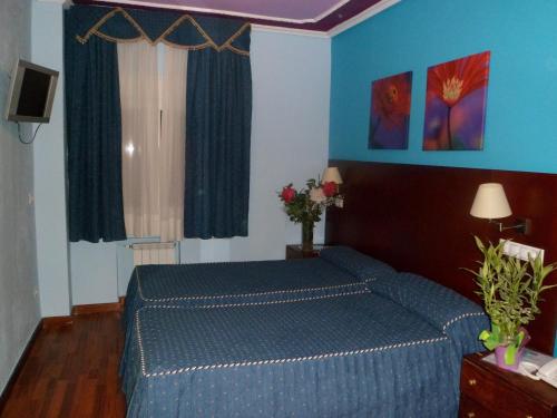 哈卡Auto Check In Hotel Las Nieves的一间卧室设有蓝色的床和蓝色的墙壁