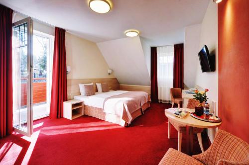 斯克拉斯卡波伦巴Hotel Willa Odkrywców的酒店客房配有一张床铺和一张桌子。