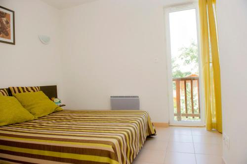 欧兹阿马尼亚克塔高尔夫公寓的一间卧室配有一张黄色和白色毯子的床