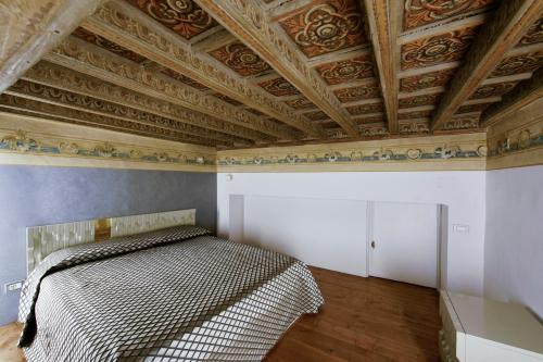 都灵Turin Art Experience的一间卧室设有一张床和格子天花板