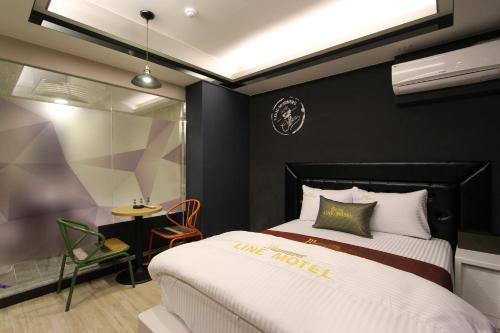 大邱线路汽车旅馆的酒店客房配有一张床铺和一张桌子。