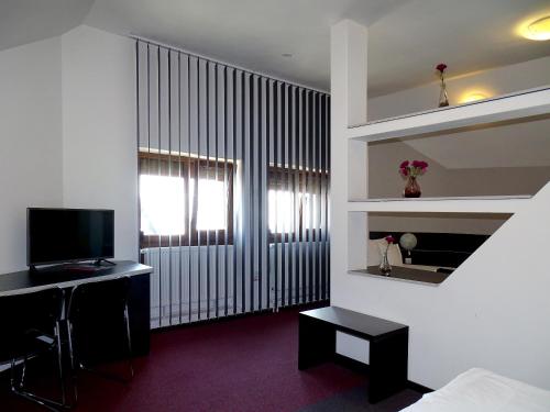 密古雷休治Prince Hotel的客房设有床、书桌和电视。