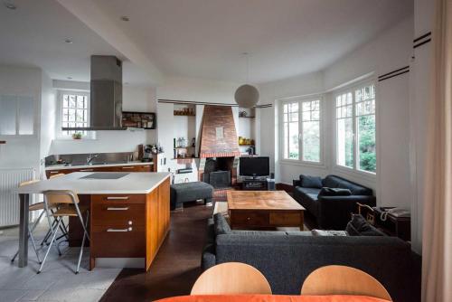 迪纳尔la Pinède的厨房以及带沙发和桌子的客厅。