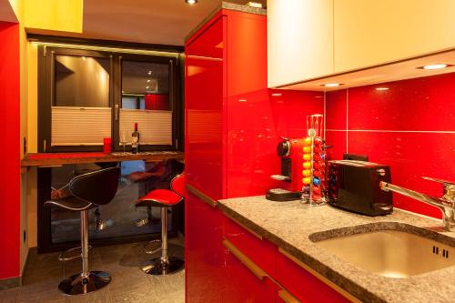 采尔马特Schirle的红色的厨房,配有水槽和红色橱柜