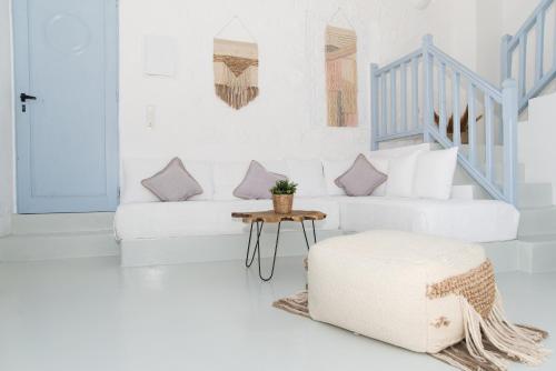 帕特莫斯Patmos Sunshine Houses的白色的客厅配有白色的沙发和凳子