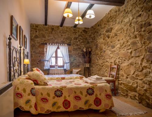 纳瓦孔塞霍El Cerrillo的一间卧室设有一张床和石墙