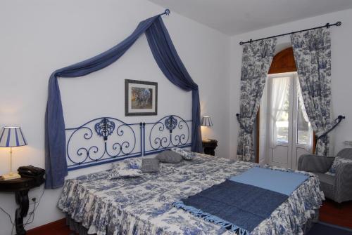 阿布兰特什凝乳TH农家乐的卧室配有蓝色和白色的床和椅子