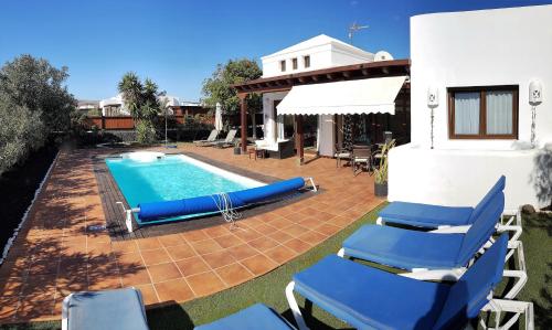 普拉亚布兰卡Villa Marina1的一个带蓝色椅子的游泳池