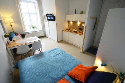 琴斯托霍瓦Studio Aleja 77的一间卧室配有一张床铺和一张桌子,还设有一间厨房