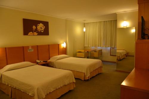 蓬塔格罗萨巴布广场酒店的酒店客房设有两张床和一张桌子。