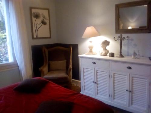 肖蒙La corniche的一间卧室配有一张床、一把椅子和一个梳妆台
