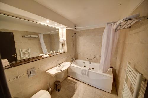 布加勒斯特Atrium Hotel Ateneu City Center的带浴缸、盥洗盆和卫生间的浴室