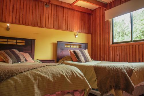 卡斯特鲁帕拉菲托斯渔村度假屋的木镶板客房内的两张床