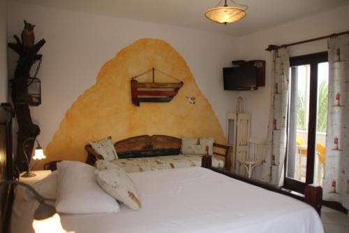圣安娜纳克索斯维拉达纳伊酒店的一间卧室配有一张带大型岩石墙的床