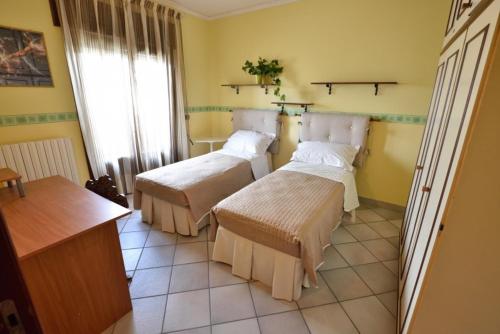 梅利萨诺Appartamento Orchidea的一间客房内配有两张床的房间