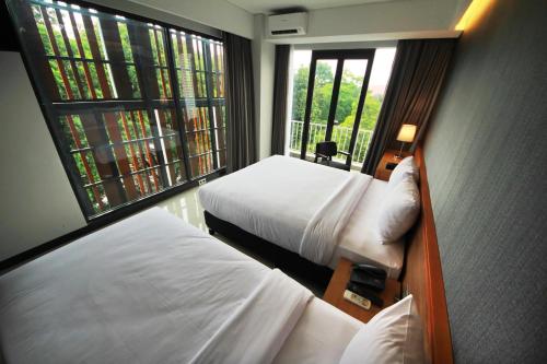万隆万隆禾意酒店的酒店客房设有两张床和窗户。