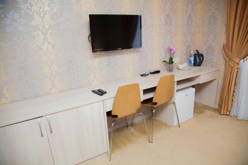 喀山斯达格洛德酒店的一张桌子、两把椅子和墙上的电视
