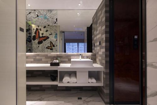 广州柏高雅酒店(广州东圃天河城店)的一间带水槽和镜子的浴室
