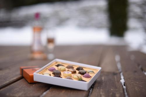 奥多尔黑塞库耶斯克Horizont Panzio的木桌上一盒巧克力覆盖的甜甜圈