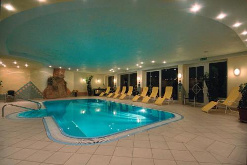 施特格Hotel Styrolerhof的酒店的大型游泳池周围设有椅子