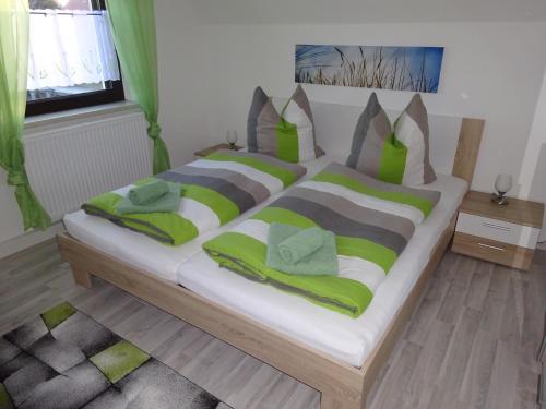 MalschwitzFerienhaus Oberlausitz的卧室配有一张带绿色和灰色枕头的大床