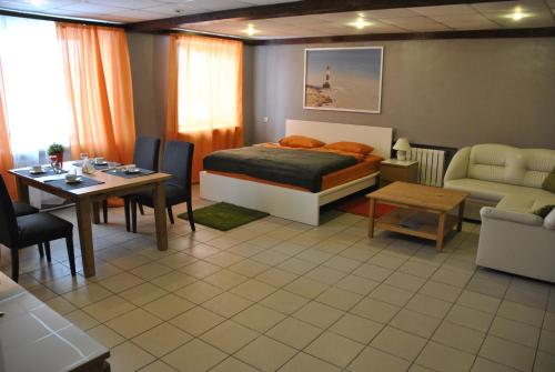 彼尔姆Hotel Albatros的一间卧室配有一张床铺和一张桌子,还有一间用餐室