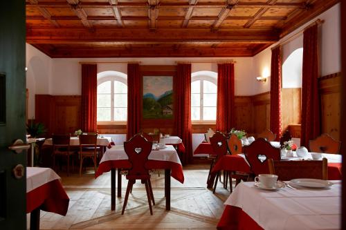 塞斯托多罗米特诺夫阿尔特波斯特酒店的一间带桌椅和红色桌布的用餐室