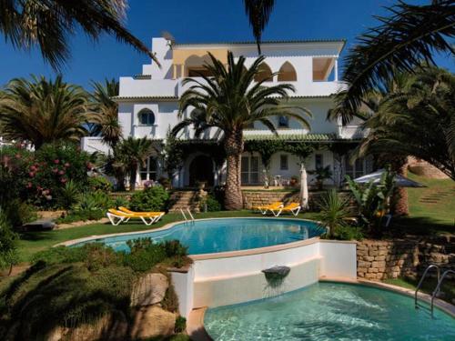 拉戈斯Villa Esmeralda的一座大房子,房子前面设有一个游泳池