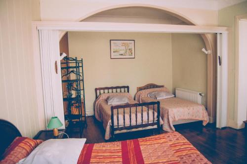 沙托鲁莫里斯餐厅酒店的一间卧室设有两张床和一个拱形门廊。