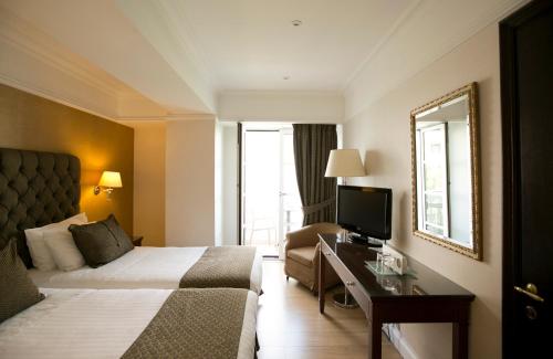 雅典赫拉酒店的酒店客房,配有床和电视