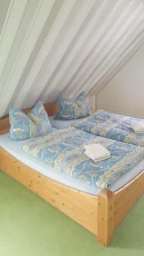 布雷格Kapitänskoje的一张带蓝色床单和枕头的木床