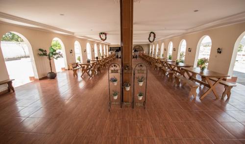 Passa e FicaPousada e Restaurante Manaím的大房间设有桌子、长凳和窗户