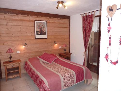 Feissons-sur-SalinsChalet Le Tredard的一间卧室设有一张床和木墙