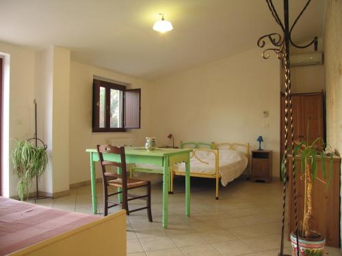 孔韦尔萨诺Masseria dei Monelli的客厅配有绿桌和床。