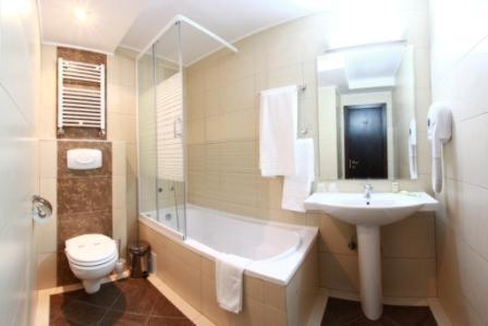 克拉约瓦悉尼酒店的一间带水槽、浴缸和卫生间的浴室