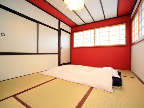 京都カモンイン 稲荷的卧室设有红色和白色的墙壁和床